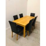 A Contemporary oak dining table with six faux brown leather chairs.