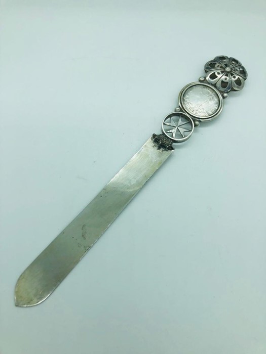 A silver letter opener with coin inset in the handle