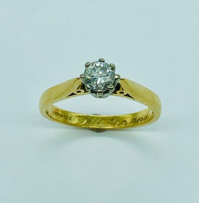 An 18ct yellow gold ring with a central diamond (3.2g)