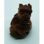 A Carved Wooden Netsuke in the Form of a Dragon