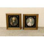 A Pair Gilt Framed His and Her Portraits in Black Oval Glass Mounts