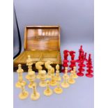 A Red and White Antique Ivory Chess set in a games box. ( King 7.5cm Queen 6.5cm)