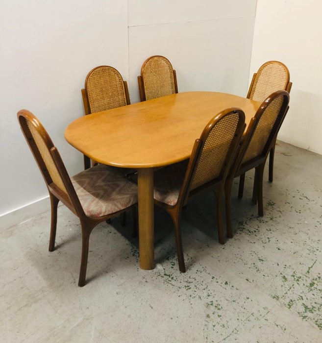 A 1970's Dining Table with six cane back chairs.