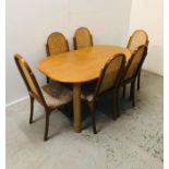 A 1970's Dining Table with six cane back chairs.