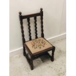 A small carved oak chair with Barley twist legs and back and a floral tapestry seat