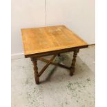 An Extendable Oak Dining Table with Crossed Base