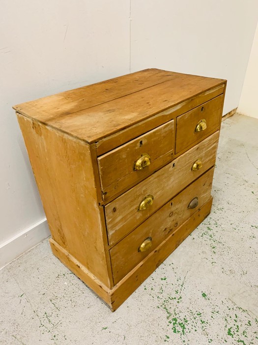 A Two over two pine chest of drawers with brass cup handles. - Image 4 of 4