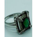 A Silver CZ Dress Ring with Faux Emerald Central Stone