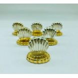 A Set of six decorative gold and silver coloured shell design place setting holders