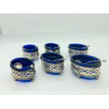 A Set of six silver salts with blue glass liners and silver spoons
