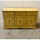 A Pale yellow hand painted pine sideboard with three drawers and three cupboards (W143cm H85cm