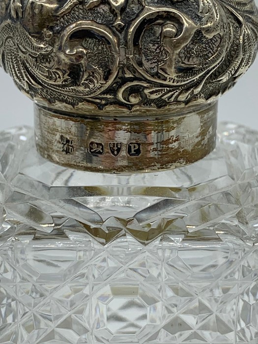 A cut glass scent bottle with hallmarked silver repousse lid - Image 2 of 2