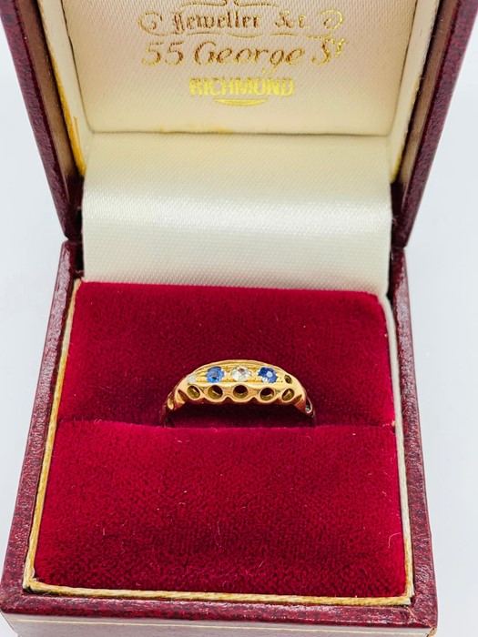 An 18ct yellow gold ring with three small stones.