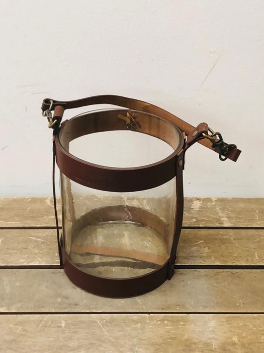 A Leather and glass hurricane style candle holder