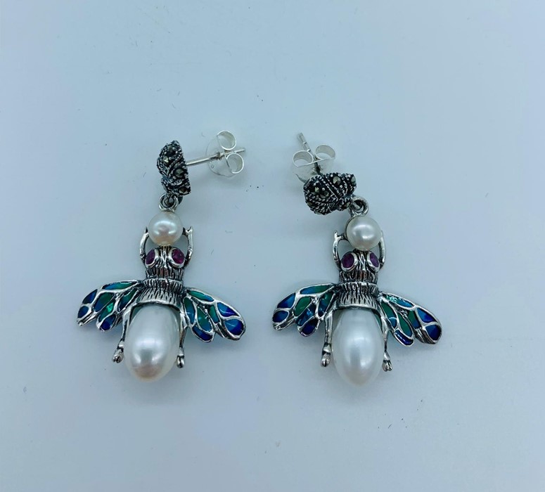 A Pair of silver plique a jour earrings in the form of bees with ruby eyes