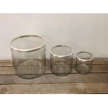 Three metal rimmed glass hurricane vases