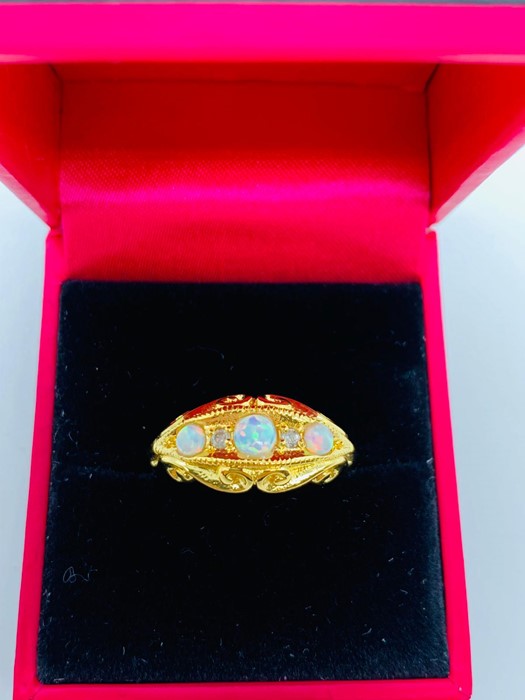A Victorian style ring set with three opals