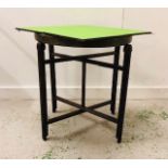 A folding card/games table with art deco art brass table top
