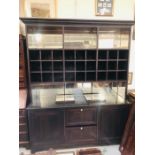 A Large heavy dark wood contemporary cabinet with shelves and cubby holes above and mirrored