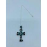 A silver crucifix set with cz's turquoise and ruby panels