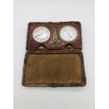 A Swiss made travel clock, a barometer and temperature gauge in a leather case