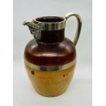 A Large stoneware Ale jug with white metal handle, trim and spout in the form of a bearded