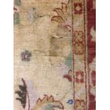 A Golden grounds hand knotted Turkish rug with red boarder (266cm X 286cm)