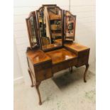 A Large three mirrored walnut dressing table on cabriole legs with four drawers and carving to the