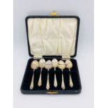 A set of silver, hallmarked teaspoons in a black case.