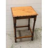 A Small oak side table with piecrust edges on barley twist legs