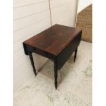 A Gate leg table with turned legs on brass castors with drawers either end ( one fake)