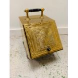 A brass coal scuttle on ebonised feet with matching handle