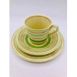A Clarice Cliff designed trio tea set, the cream ware set being decorated with lime green and gold
