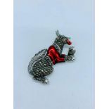 A silver marcasite and enamel brooch in the form of a dog