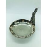 A white metal dish with standing Hare figure