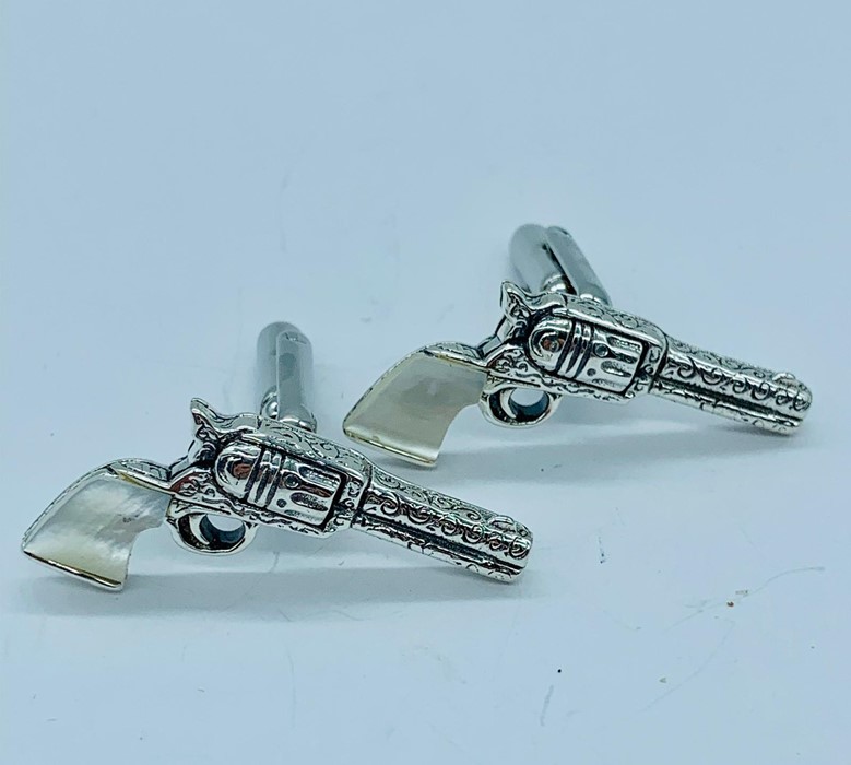 A pair of unusual silver cufflinks in the form of pistols with moonstone handles