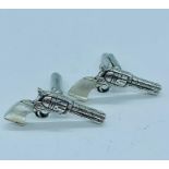 A pair of unusual silver cufflinks in the form of pistols with moonstone handles