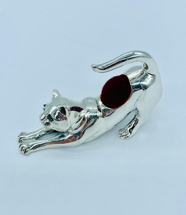 A silver leaping cat pin cushion with ruby eyes