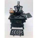 A Miniature Victorian cast iron stove with pots and pans and utensils