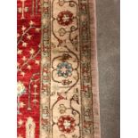An Large red ground hand knotted rug with diamond blue and white border AF(274CM X 183CM)