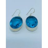 A pair of blue stone earrings set in silver.