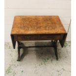 A walnut drop leaf coffee table with two drawers and brass claw feet on castors