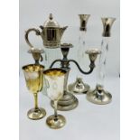 A collection of silver plated items to include candlesticks and claret jug.