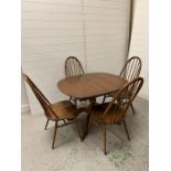 A dark wood Ercol oval table with four chairs