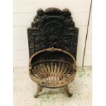 A decorative cast iron fire basket with back plate
