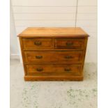 A solid pine chest of drawers two over two with brass drop handles