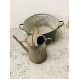 A vintage watering can and metal tub with handles