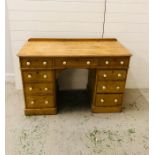 A pine double pedestal desk with nine drawers