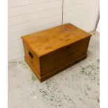 A pine blanket box with brass handles either side
