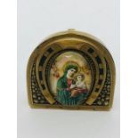 A vintage brass vesta case with religious pictorial image in a horseshoe